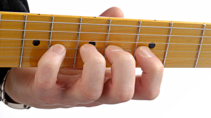 Close-up view of a guitar fretboard with different note positions