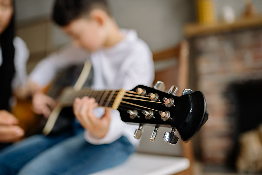 Excited young child playing a guitar