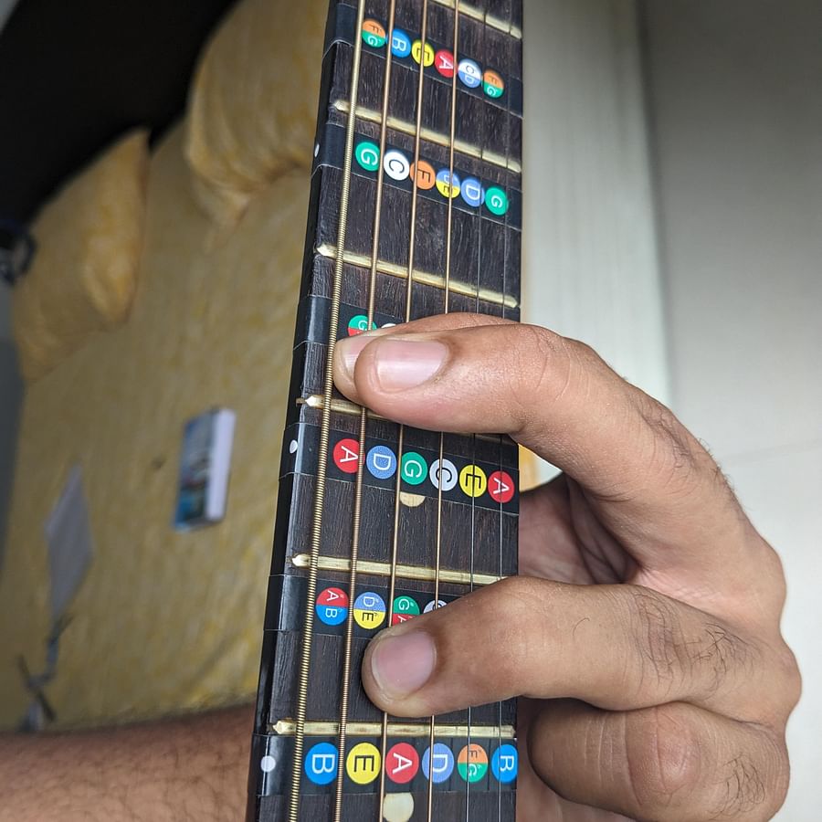 Close-up shot of a guitar fretboard with fingers forming a chord