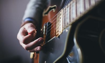 Should I find a guitar teacher or follow online tutorials to learn guitar?